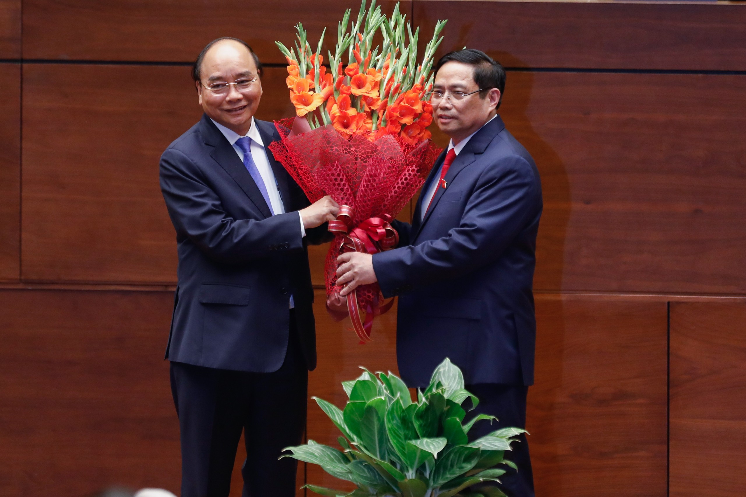 Chủ tịch nước Nguyễn Xuân Phúc tặng hoa chúc mừng tân Thủ tướng Chính phủ Phạm Minh Chính.