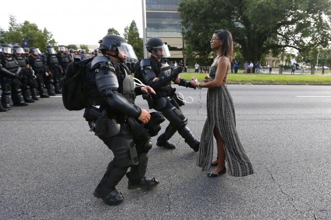Người phụ nữ trong ảnh nổi tiếng này được bạn bè của cô xác nhận có tên là Ieshia 
Evans, làm nghề y tá thực hành được cấp phép ở bang Pennsylvania - Ảnh: Reuters.<br>