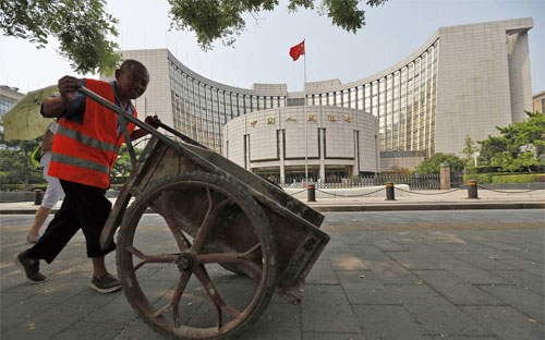 Một người công nhân đẩy xe qua trụ sở Pg88 com chính chủ Trung ương Trung Quốc (PBoC) ở Bắc Kinh - Ảnh: EPA/WSJ.<br>