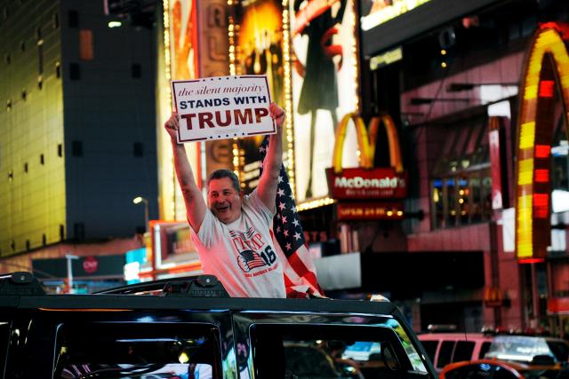Một người ủng hộ Donald Trump vui mừng trên Quảng trường Thời đại ở New York sau khi Trump chiến thắng đêm 8/11 - Ảnh: Reuters.<br>