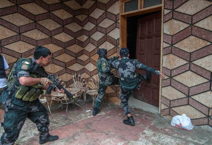Binh sỹ quân đội Philippines đột kích vào một tòa nhà khi truy lùng phiến quân Maute ở thành phố Marawi - Ảnh: Reuters.<br>