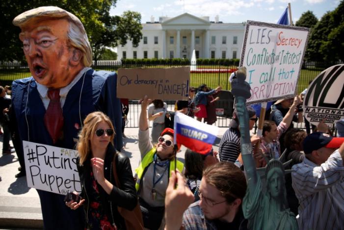 Người biểu tình phản đối việc Tổng thống Mỹ Donald Trump bất ngờ sa thải Giám đốc FBI James Comey bên ngoài Nhà Trắng ở Washington ngày 10/5 - Ảnh: Reuters.<br>