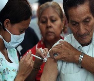 Nhân viên y tế tiêm vắcxin phòng chống cúm cho một cụ già tại Panama. 
