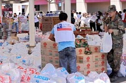 Binh sĩ Chile và nhân viên tình nguyện đóng gói PG88 xổ số, casino, bóng đá phân phát cho các nạn nhân động đất - Ảnh: AFP.