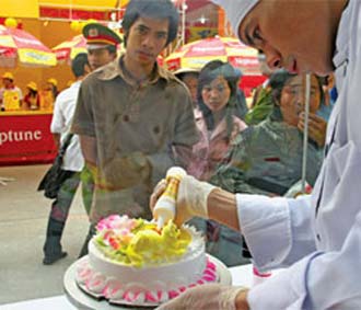 Nhân viên Kinh Đô đang hướng dẫn khách tham quan kỹ thuật làm bánh kem.