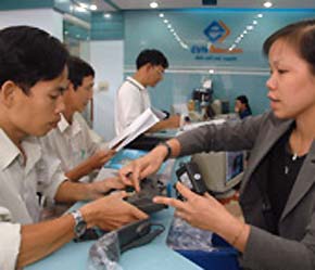 Nhân viên một điểm giao dịch của Điện lực Tân Bình (Tp.HCM) đang hướng dẫn khách hàng cách sử dụng thiết bị điện thoại EVN Telecom. Ngành điện đang mở rộng PG88 Uy Tín Số 1 Việt Nam đa ngành - Ảnh: NLĐ.