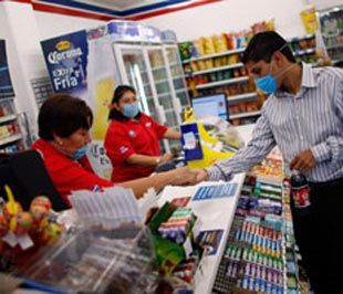 Nhân viên bán hàng và khách cùng đeo khẩu trang phòng cúm lợn trong một siêu thị ở Mexico - Ảnh: Getty Images/Economist.