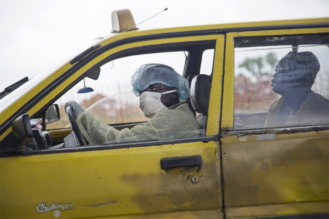 Một người lái xe taxi đang đưa một phụ nữ bị ốm tới khám tại một trung tâm điều trị Ebola ở thủ đô Monrovia của Liberia hôm 4/9. <br>