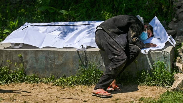 Umar Farooq đau khổ b&ecirc;n thi thể người mẹ tử vong v&igrave; Covid-19, ở Srinagar h&ocirc;m 26/4 - Ảnh: Getty/CNBC.