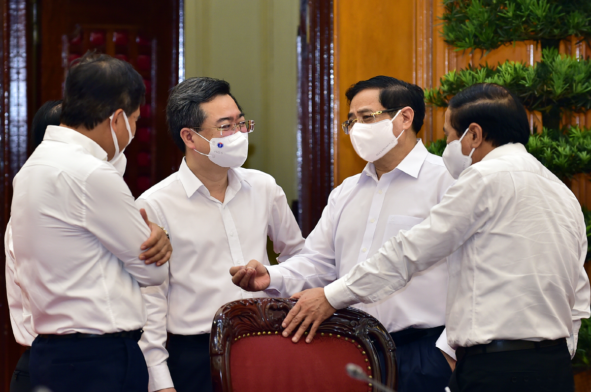 Thủ tướng Phạm Minh Ch&iacute;nh trao đổi với Ph&oacute; Thủ tướng L&ecirc; Văn Th&agrave;nh, Bộ trưởng Bộ X&acirc;y dựng Nguyễn Thanh Nghị v&agrave; c&aacute;c đại biểu dự cuộc l&agrave;m việc - Ảnh: VGP.