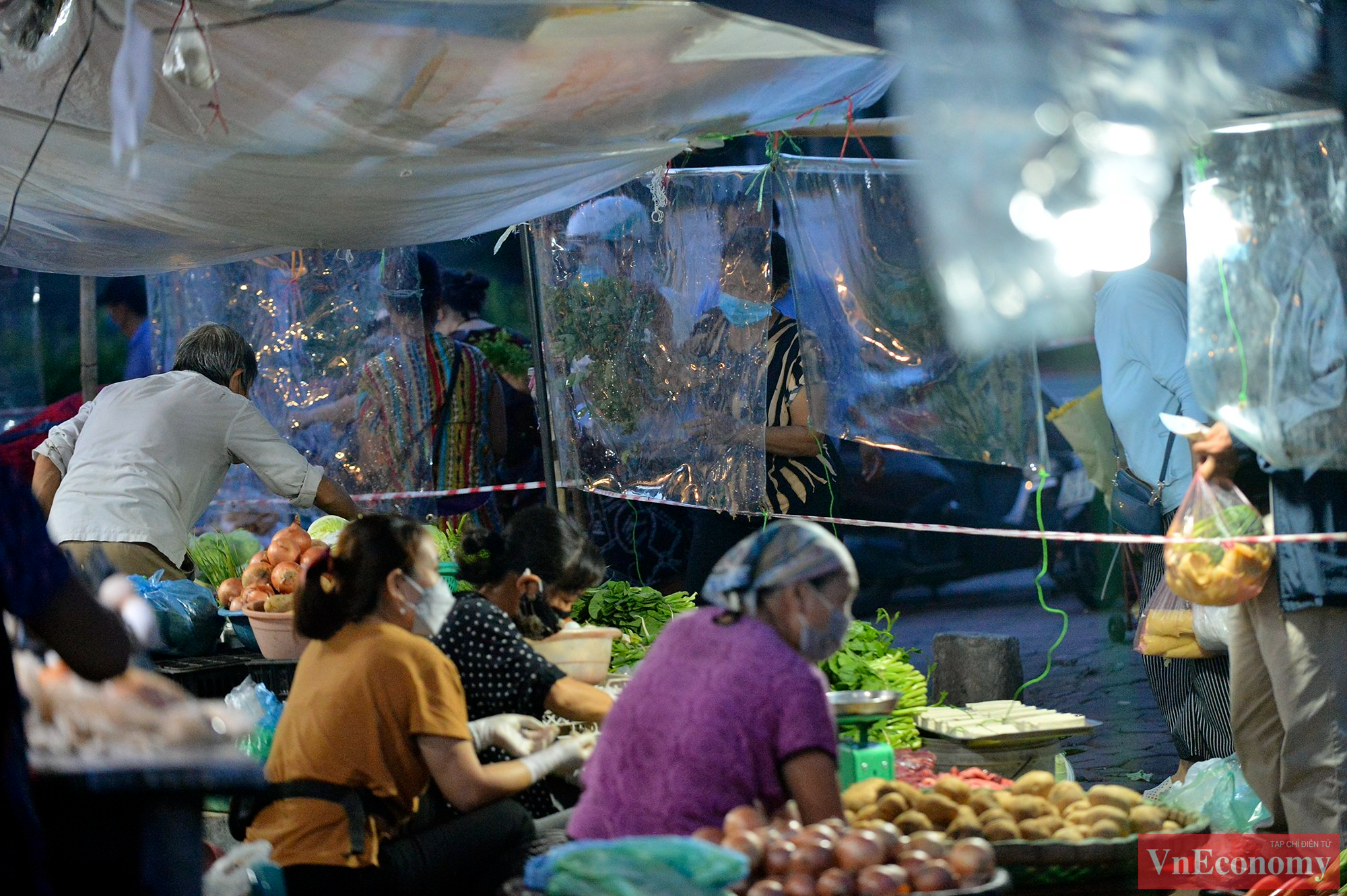 Tại chợ Ng&atilde; Tư Sở (phường Ng&atilde; Tư Sở, quận Đống Đa), b&agrave; con tiểu thương chủ động căng d&acirc;n, căng tấm chắn giọt bắn để&nbsp;ph&ograve;ng chống dịch bệnh.