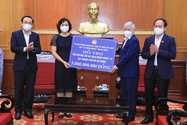 Chủ tịch Uỷ ban Trung ương Mặt trận Tổ quốc Việt Nam Đỗ Văn Chiến trao số tiền 5 tỷ đồng hỗ trợ trẻ em mồ côi do dịch bệnh Covid-19 tại TP.HCM. Ảnh - Quang Vinh. 