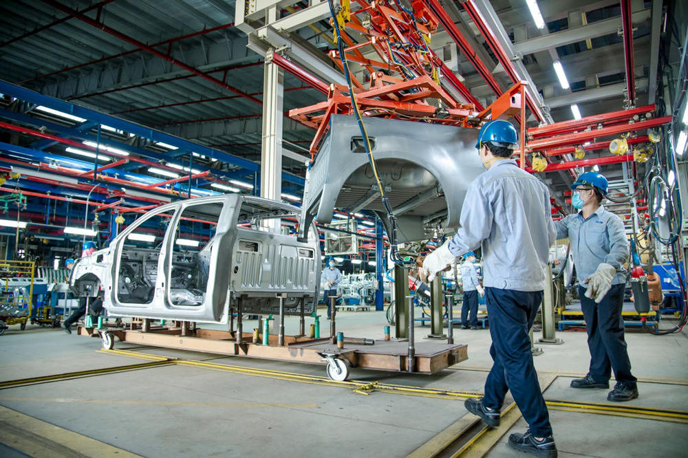 C&ocirc;ng nh&acirc;n nh&agrave; m&aacute;y di chuyển một phần th&acirc;n xe với sự hỗ trợ của d&acirc;y chuyền lắp r&aacute;p tự động tại nh&agrave; m&aacute;y Ford Hải Dương.