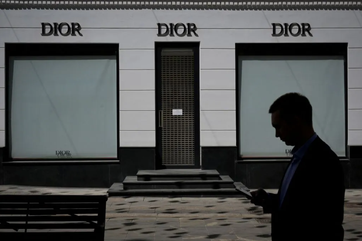 Một người đ&agrave;n &ocirc;ng đi ngang qua một cửa h&agrave;ng Dior đ&atilde; đ&oacute;ng cửa ở Moscow, Nga ng&agrave;y 8/6/2022 - Ảnh: Getty Images