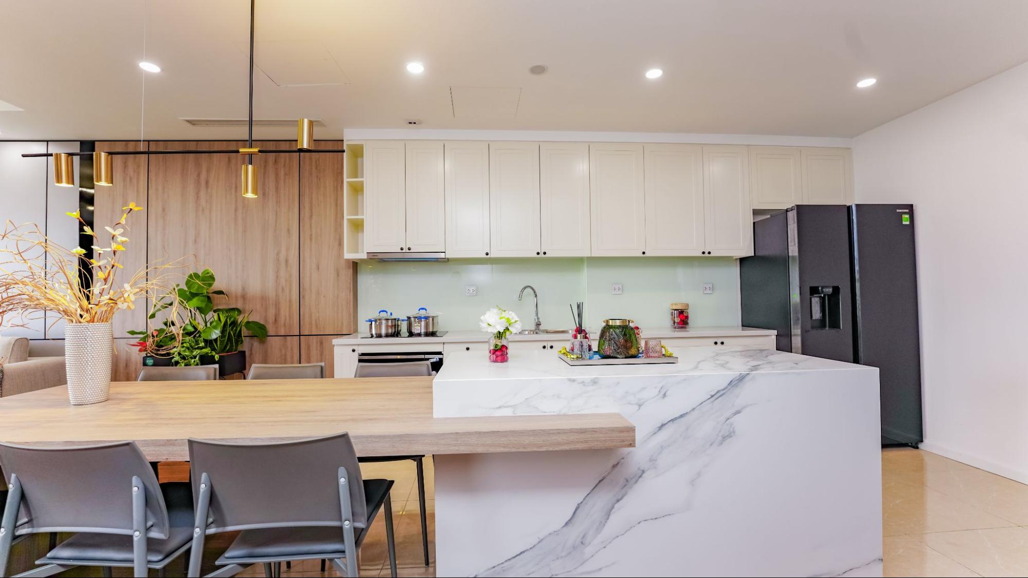 Trong khi đ&oacute;, c&aacute;c thiết bị đến từ Hafele - thương hiệu nội thất cao cấp từ Đức chiếm trọn kh&ocirc;ng gian nh&agrave; bếp: từ bếp nấu đến m&aacute;y h&uacute;t m&ugrave;i, v&ograve;i rửa, chậu rửa&hellip;