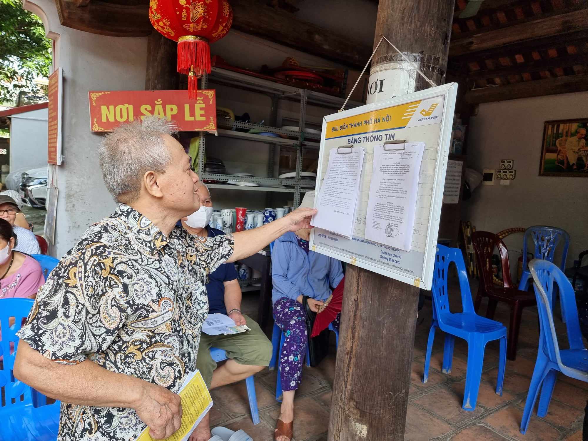 Người d&acirc;n theo d&otilde;i th&ocirc;ng tin chi trả lương hưu tại H&agrave; Nội. Ảnh - Xu&acirc;n Cường.