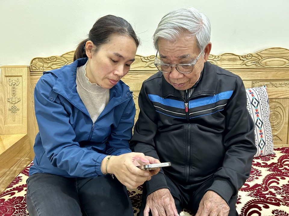 Hướng dẫn người nhận trợ cấp qua tài khoản tại Hà Nội. Ảnh - Thủy Trúc. 
