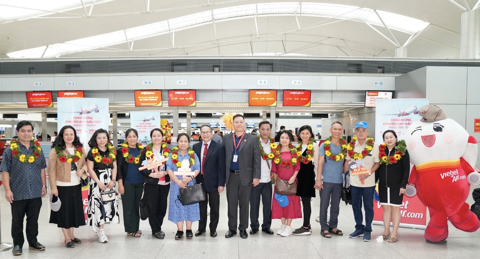 Phó Tổng lãnh sự Lào tại Tp.HCM, ông Souvannaseng Amphay cùng lãnh đạo Vietjet tặng hoa và chúc mừng những hành khách đầu tiên trên chuyến bay khai trương từ Tp.HCM đi Viêng Chăn, Lào. 