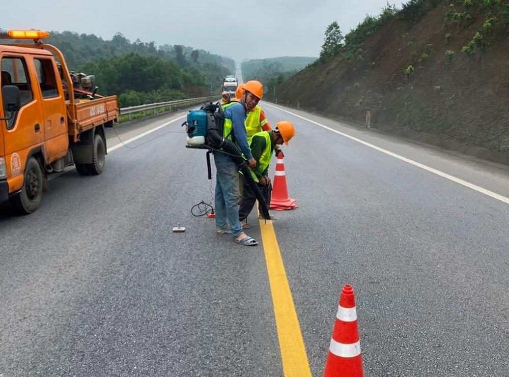 C&ocirc;ng nh&acirc;n đang sơn kẻ vạch v&agrave; c&aacute;c việc kh&aacute;c trong g&oacute;i hệ thống an to&agrave;n được bổ sung cho cao tốc Cam Lộ - La Sơn. (Ảnh: N.V)