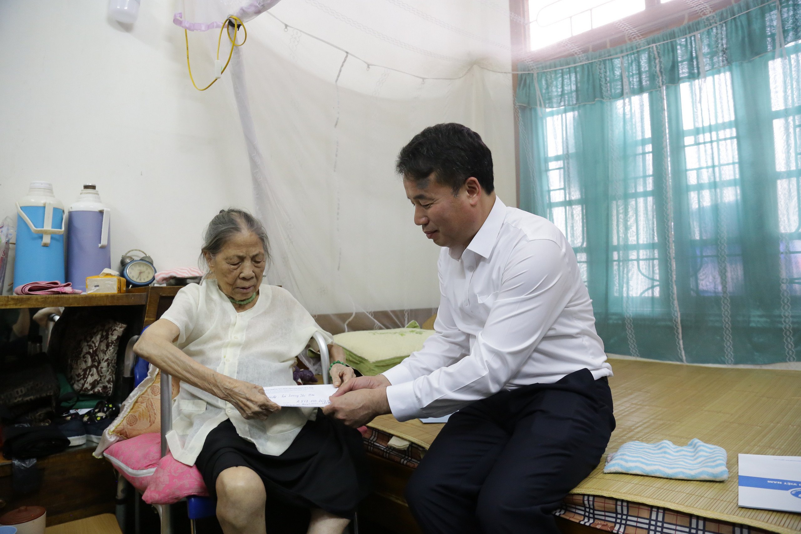 Tổng Gi&aacute;m đốc Bảo hiểm x&atilde; hội Việt Nam Nguyễn Thế Mạnh trao lương hưu tại nh&agrave; cho b&agrave; Lương Thị Hai (H&agrave; Đ&ocirc;ng, H&agrave; Nội).