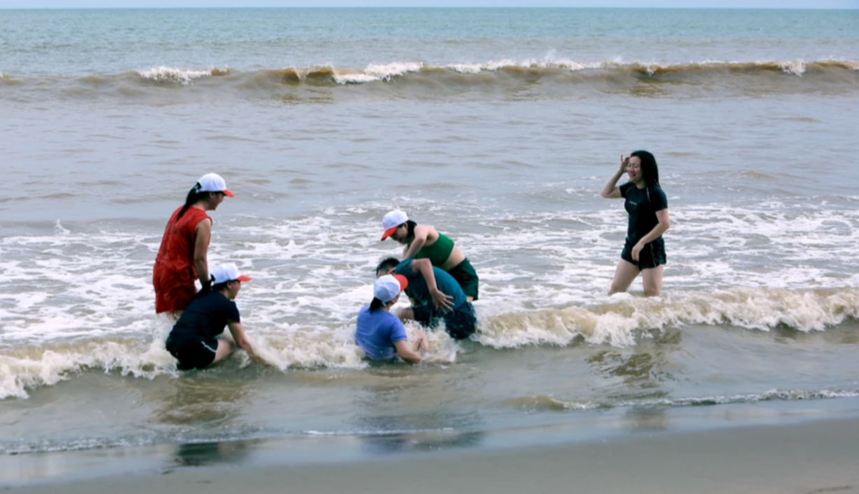 Nh&oacute;m du kh&aacute;ch v&ocirc; tư đ&ugrave;a nghịch tr&ecirc;n biển d&ugrave; c&aacute;c phương tiện b&aacute;o đ&agrave;i truyền th&ocirc;ng đưa tin về si&ecirc;u b&atilde;o Yagi.