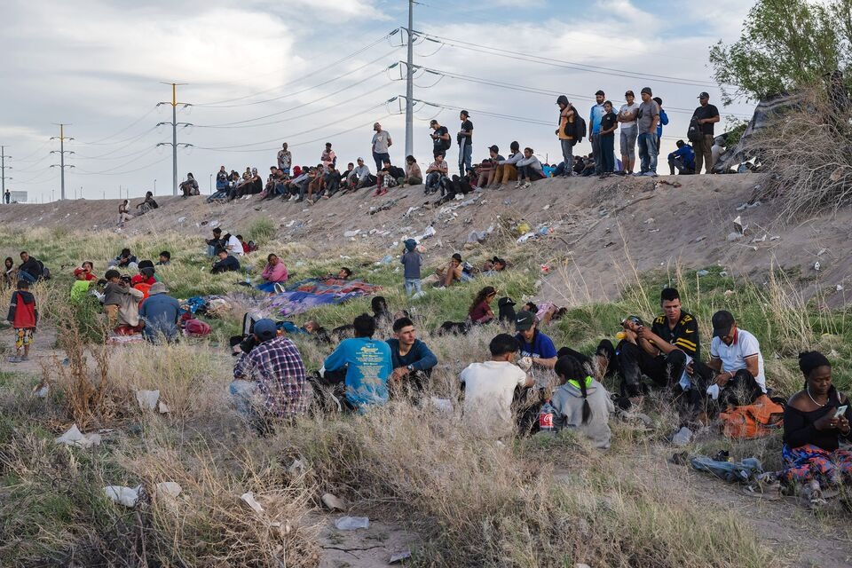 Người di cư ngồi b&ecirc;n bờ s&ocirc;ng Rio Grande tại bi&ecirc;n giới Mỹ-Mexico ở Ciudad Juarez, Mexico v&agrave;o th&aacute;ng 4 - Ảnh:Bloomberg