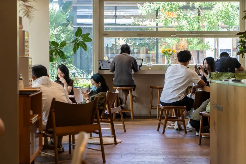 Qu&aacute;n c&agrave; ph&ecirc; trở th&agrave;nh trung t&acirc;m l&agrave;m việc của nhiều bạn trẻ. Ảnh: The New York Times