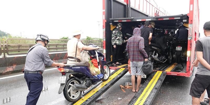 Nhiều xe tải qua đây đã dừng lại cùng lực lượng cảnh sát PG 888 Casino Uy Tín Số 1 hỗ trợ đưa các phương tiện xe máy lên thùng xe để di chuyển qua các điểm ngập