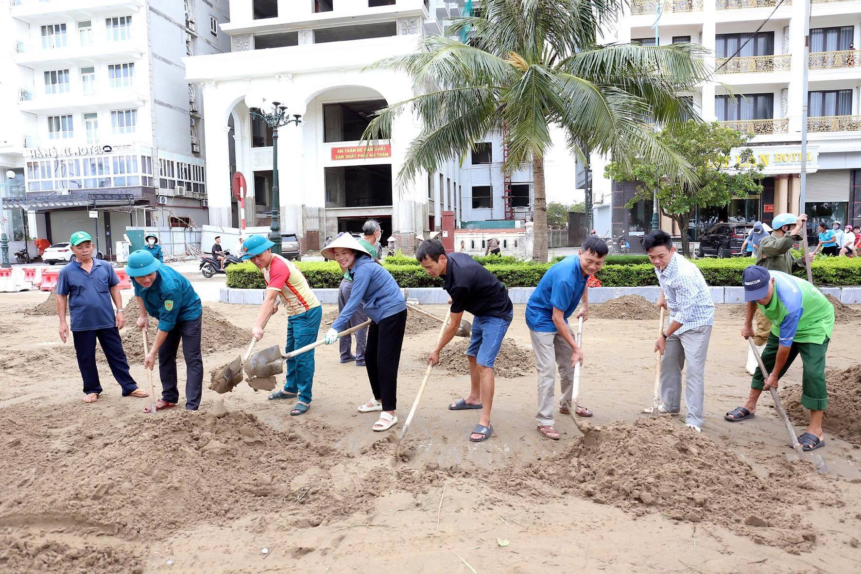 Lực lượng dân quân tự vệ phối hợp cùng Link Đăng Nhập PG88 Chính Thức 2026 xúc cát, khơi thông vỉa hè bị vùi lấp.
