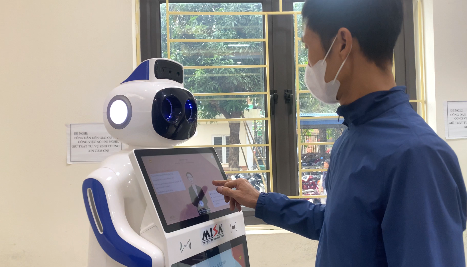 Người dân thao tác giao tiếp với robot lễ tân tích hợp trí tuệ nhân tạo tại Trung tâm Phục vụ Pg88hi nạp rút siêu tốc công xã Triệu Sơn