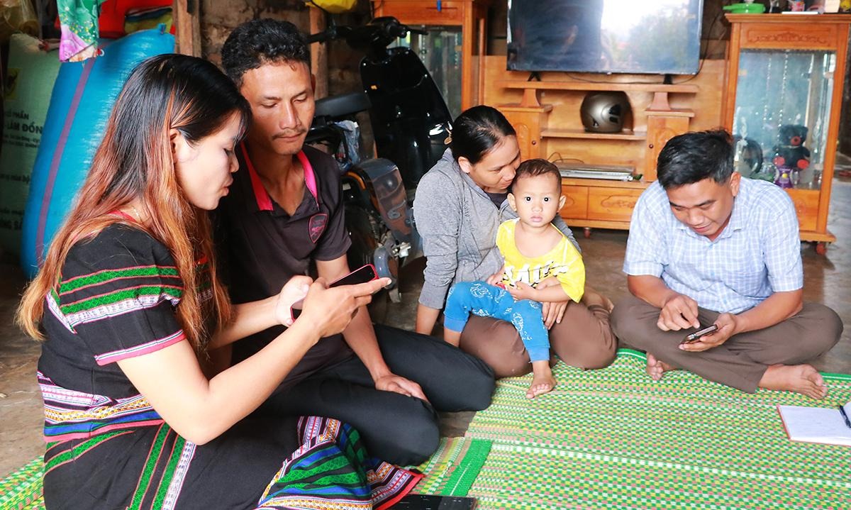 Cán bộ xã Nam Ka tuyên truyền, hướng dẫn người dân chủ động tiếp cận thông tin qua điện thoại di động. Ảnh: Thanh Xuân
