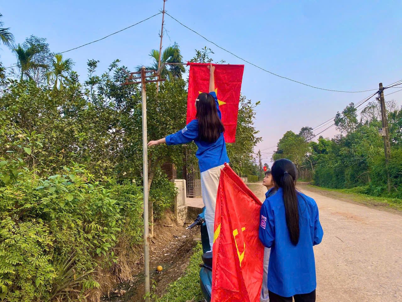 Các đoàn viên, thanh tiên treo cờ Đảng và cờ Tổ Quốc