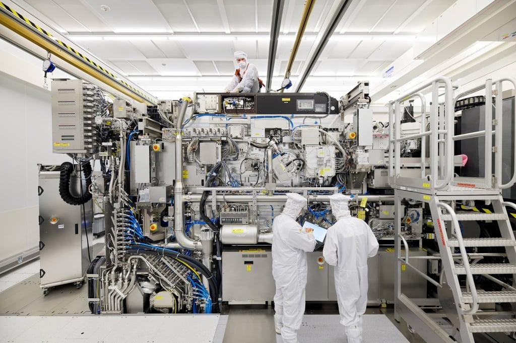 Các nhân viên của ASML đang làm việc lắp ráp giai đoạn cuối cùng của một máy in thạch bản cực tím, với các tấm vỏ ngoài đã được tháo ra, tại nhà máy của công ty ở Veldhoven, Hà Lan.