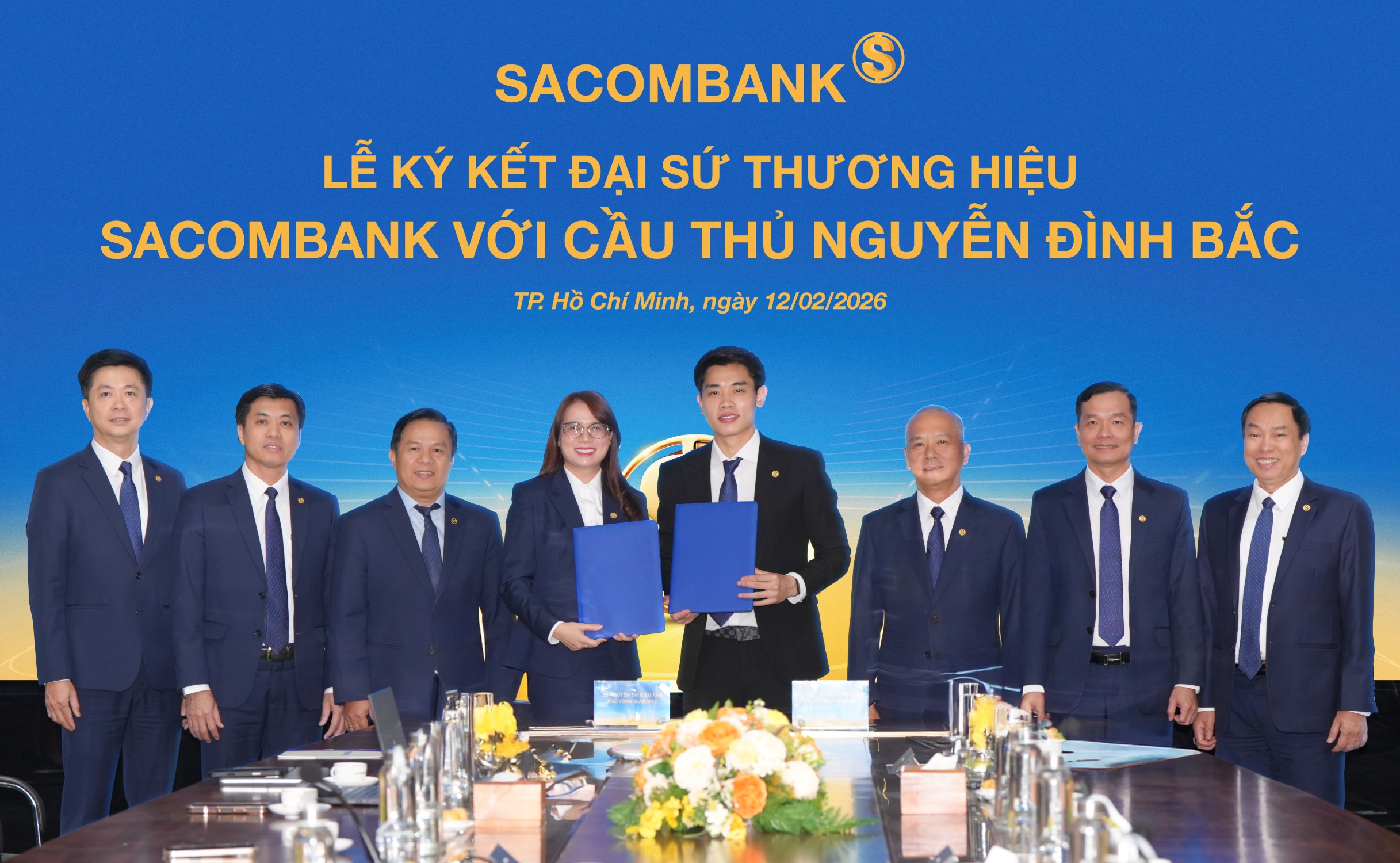 Cầu thủ Nguyễn Đình Bắc (phải) và bà Nguyễn Thị Kiều Anh (trái) - Phó Tổng giám đốc SACOMBANK thực hiện nghi thức ký kết Thỏa thuận Đại sứ thương hiệu dưới sự chứng kiến của Ban lãnh đạo Pg88 com chính chủ. Ảnh: SACOMBANK.