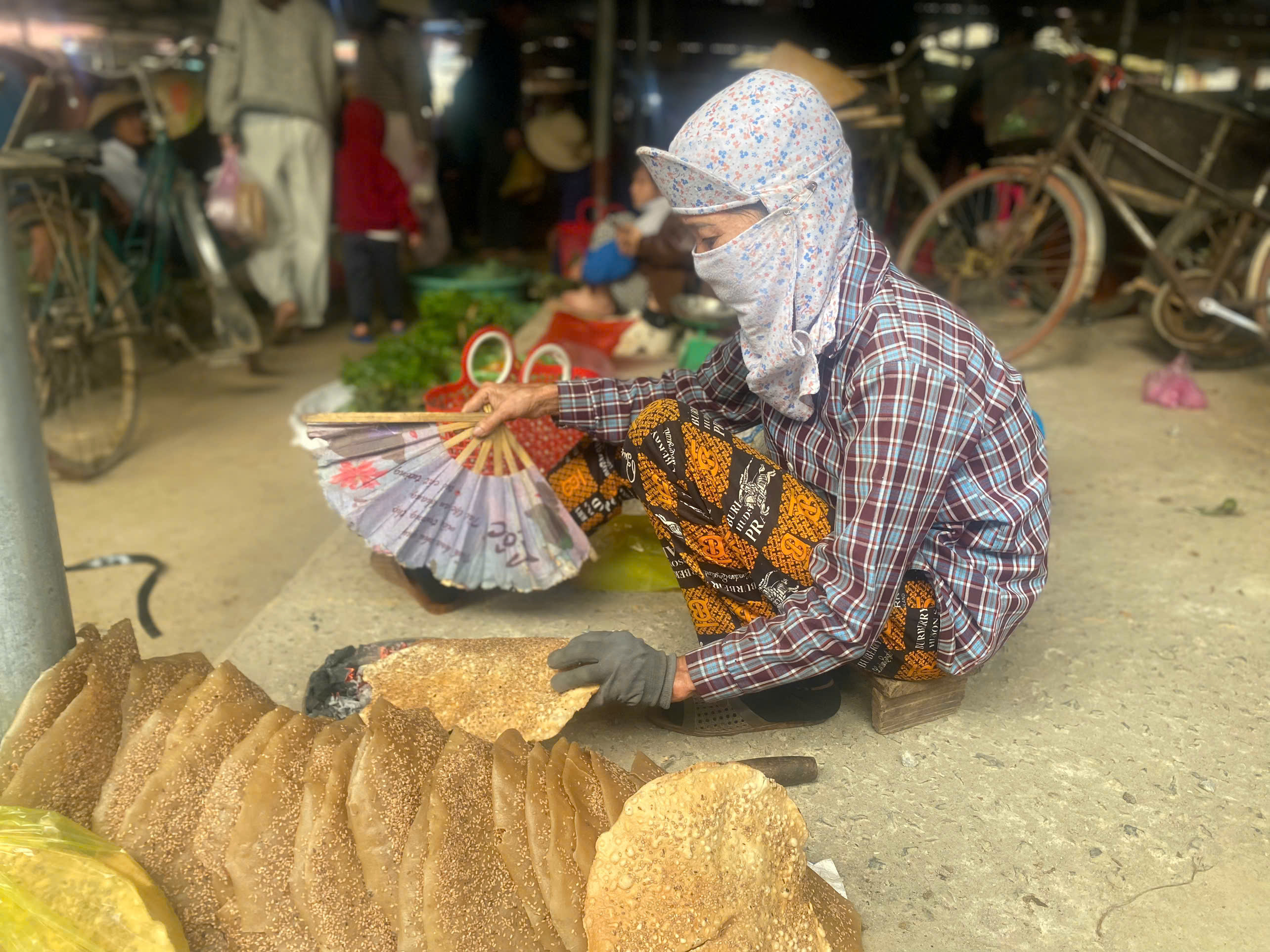 Nướng bánh đa tại các chợ quê&nbsp;là hình ảnh đặc trưng, dân dã với những chiếc bánh đa vừng được quạt trên bếp than củi hồng.