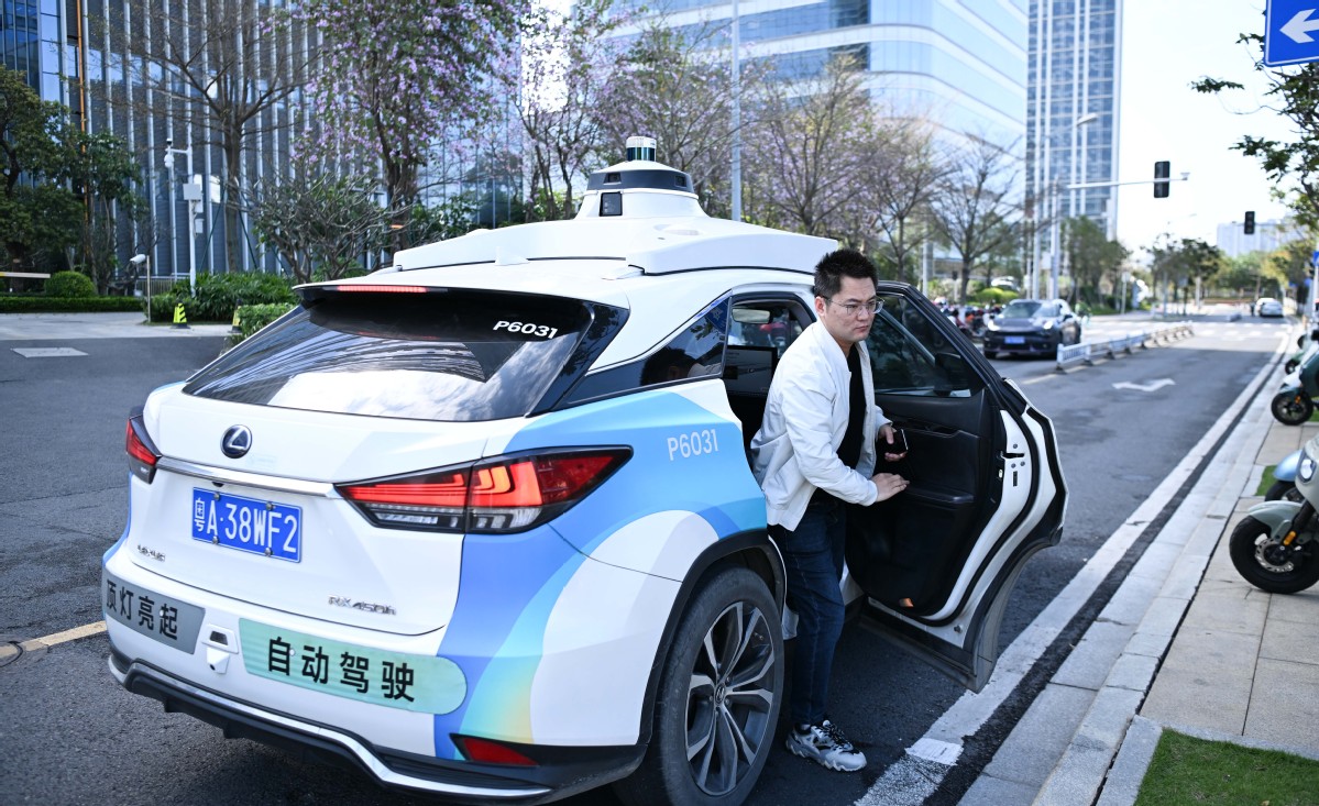 <i>Một hành khách bước xuống xe taxi tự lái không người lái tại quận Nansha, Quảng Châu. Ảnh: Xinhua.</i>