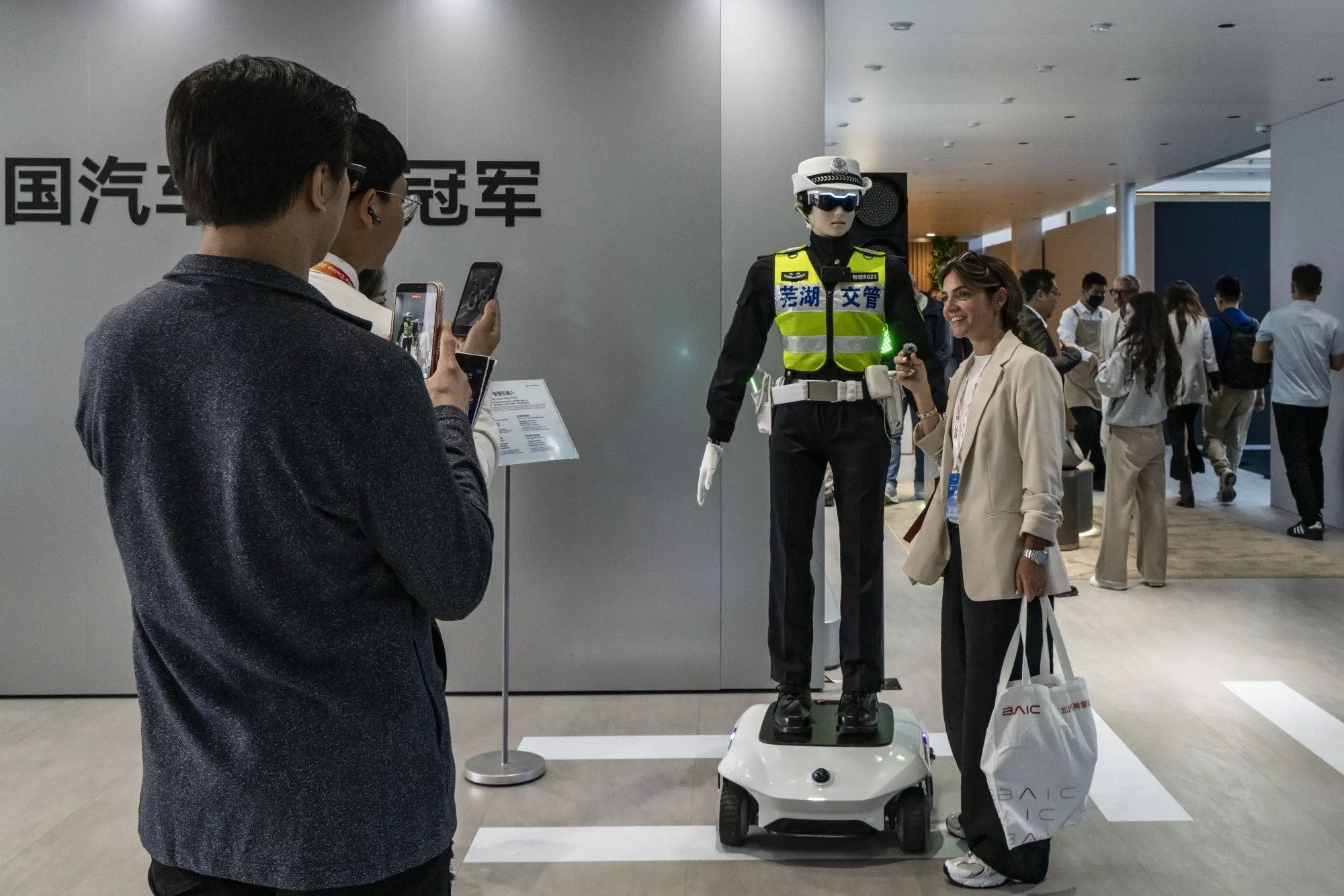 Khách tham dự chụp ảnh cùng robot điều khiển PG 888 Casino Uy Tín Số 1 hình người tại Triển lãm Ô tô Bắc Kinh. Ảnh: Bloomberg