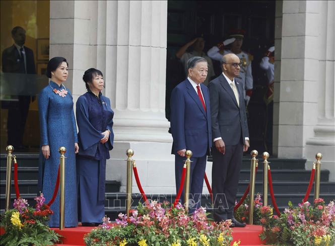 Tổng Bí thư, Chủ tịch nước Tô Lâm và Tổng thống Singapore Tharman Shanmugaratnam trên bục danh dự, nghe Quân nhạc cử Quốc thiều hai nước. Ảnh: TTXVN
